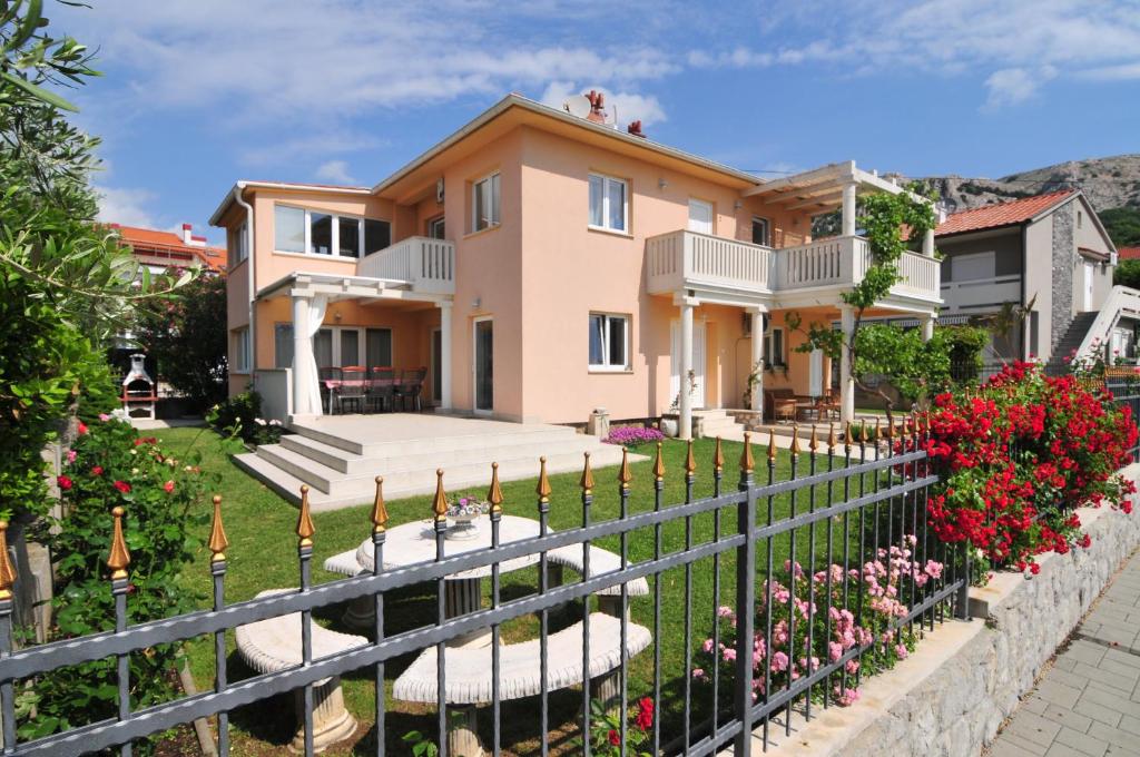 a house with a fence and flowers in the yard at Villa Schober Baška in Baška