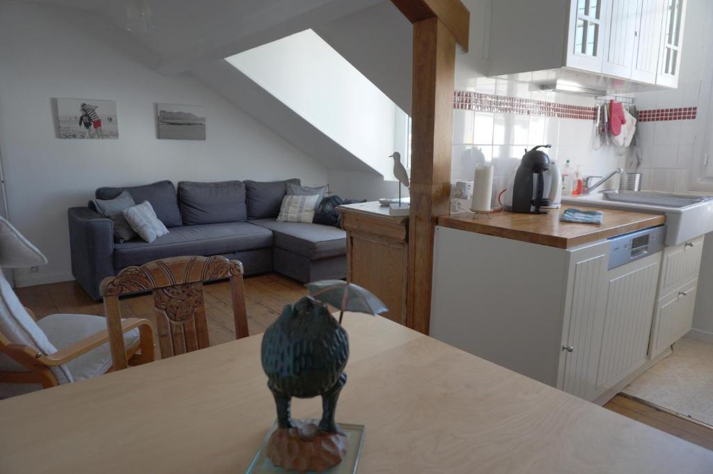 - une cuisine et un salon avec un oiseau sur une table dans l'établissement Le Proust sans souci, à Cabourg