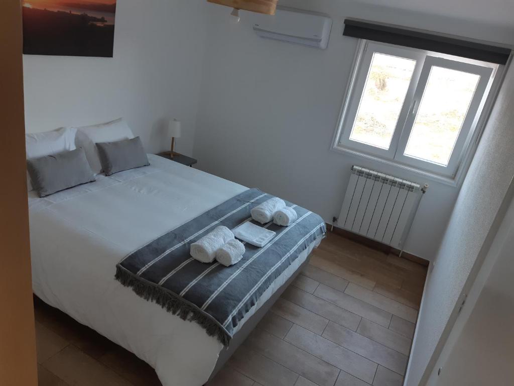 a bedroom with a bed with two towels on it at Casa do Coura in Caminha