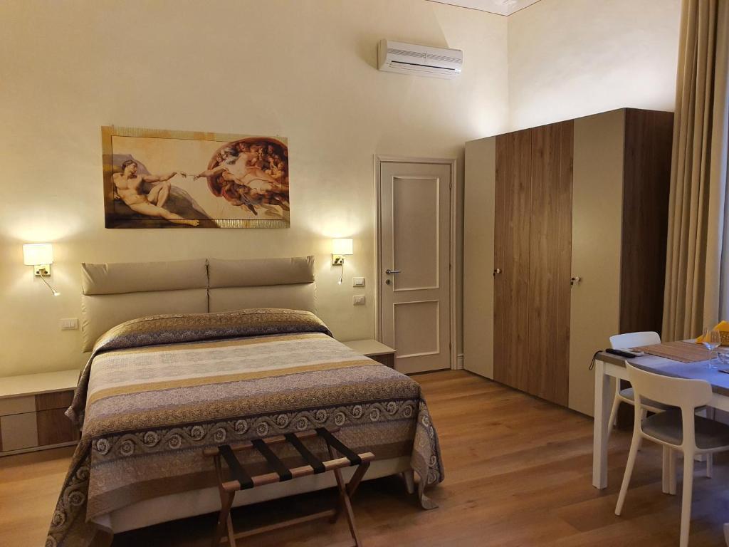 a bedroom with a bed and a table and a painting at RF Duomo suites in Florence