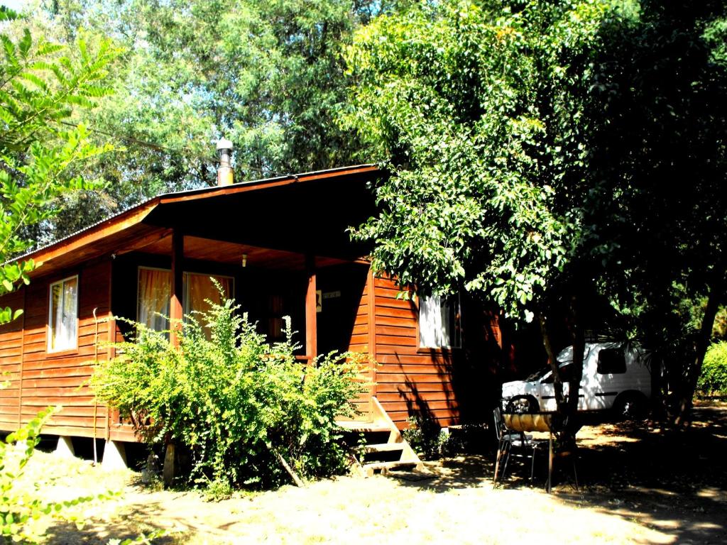 eine Holzhütte mit einem davor geparkt in der Unterkunft Cabañas Aguas Claras in Pinto