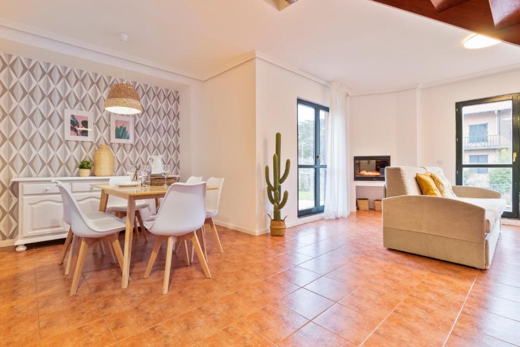 a dining room and living room with a table and chairs at Abba Comillas Apartments in Comillas