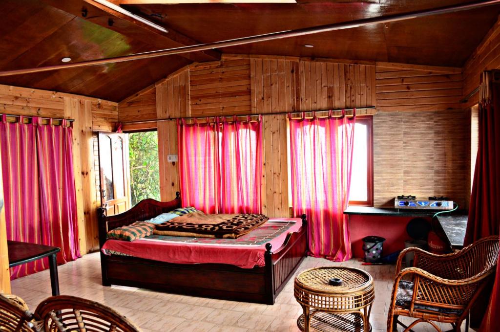 a bedroom with red curtains and a bed in a room at Venish Home Stay in Kodaikānāl