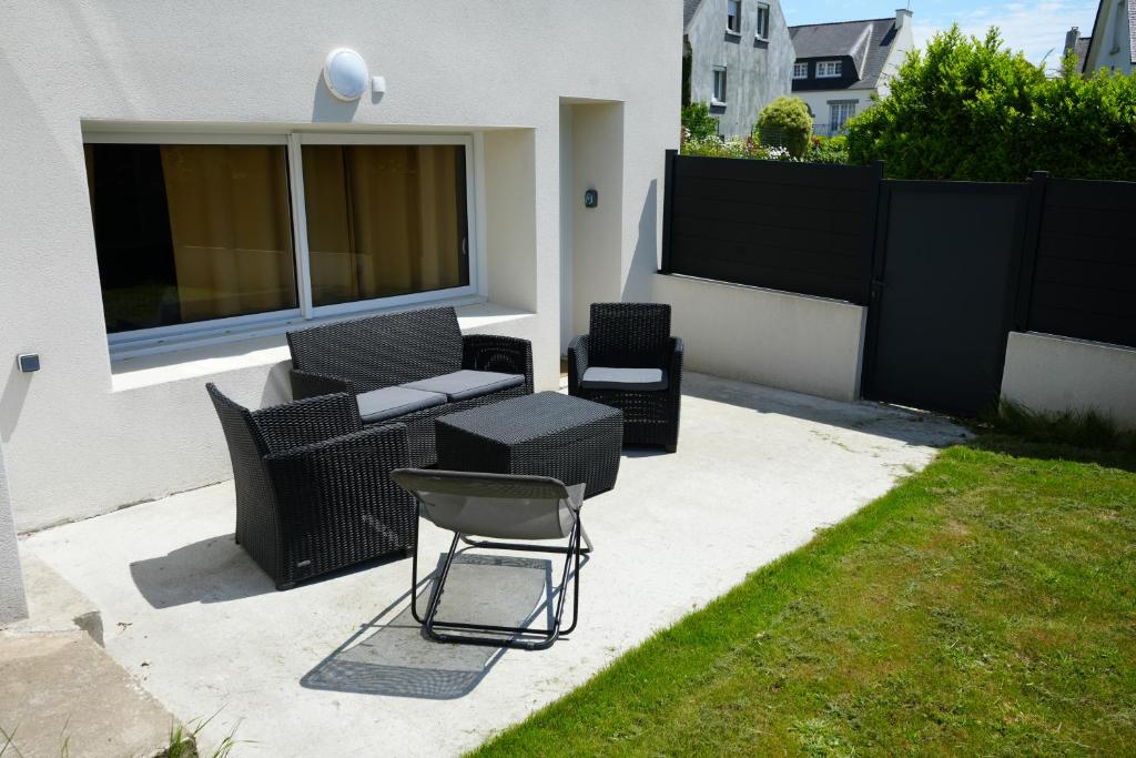 une terrasse avec un canapé, des chaises et une clôture dans l'établissement Nouveau - studio aux portes de Brest, à Bohars