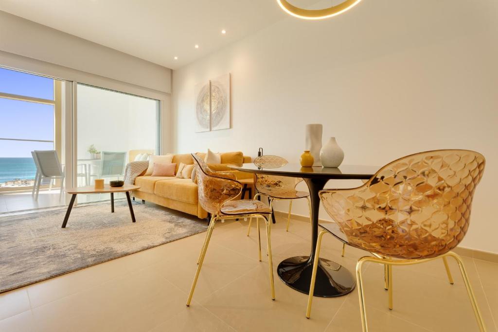 een woonkamer met een tafel en stoelen en een bank bij INTEMPO SKY RESORT by Costa Activa Rentals in Benidorm