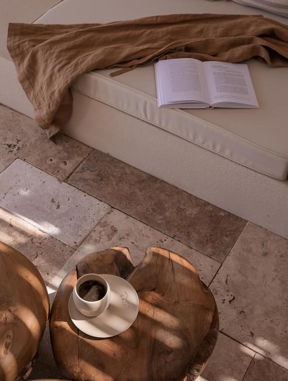 a bed with a cup of coffee and a book at GAIA Alaçatı BY THE SEA - Adult Only in Çeşme