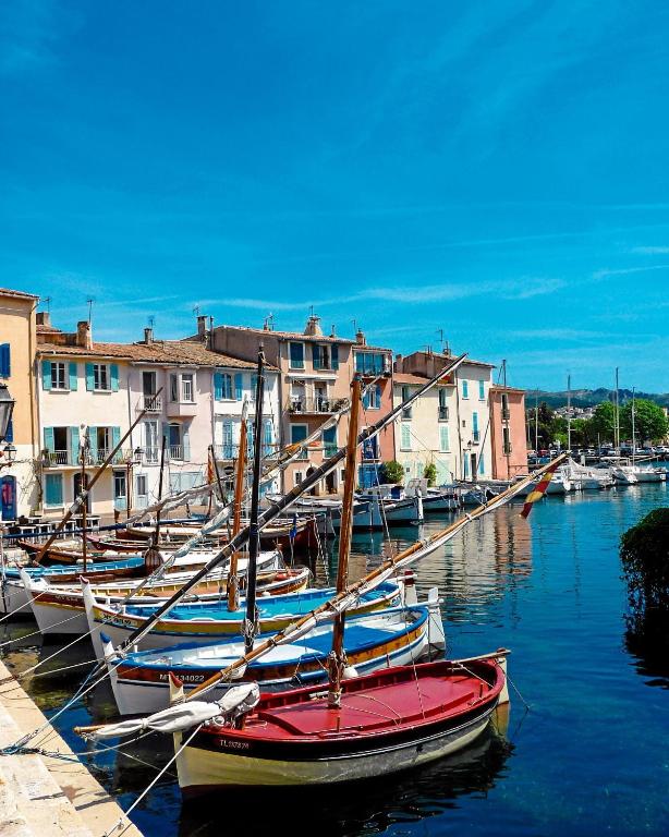 un groupe de bateaux amarrés dans un port avec des bâtiments dans l'établissement Hébergement sur l île de Martigues, la Venise provençale, à Martigues