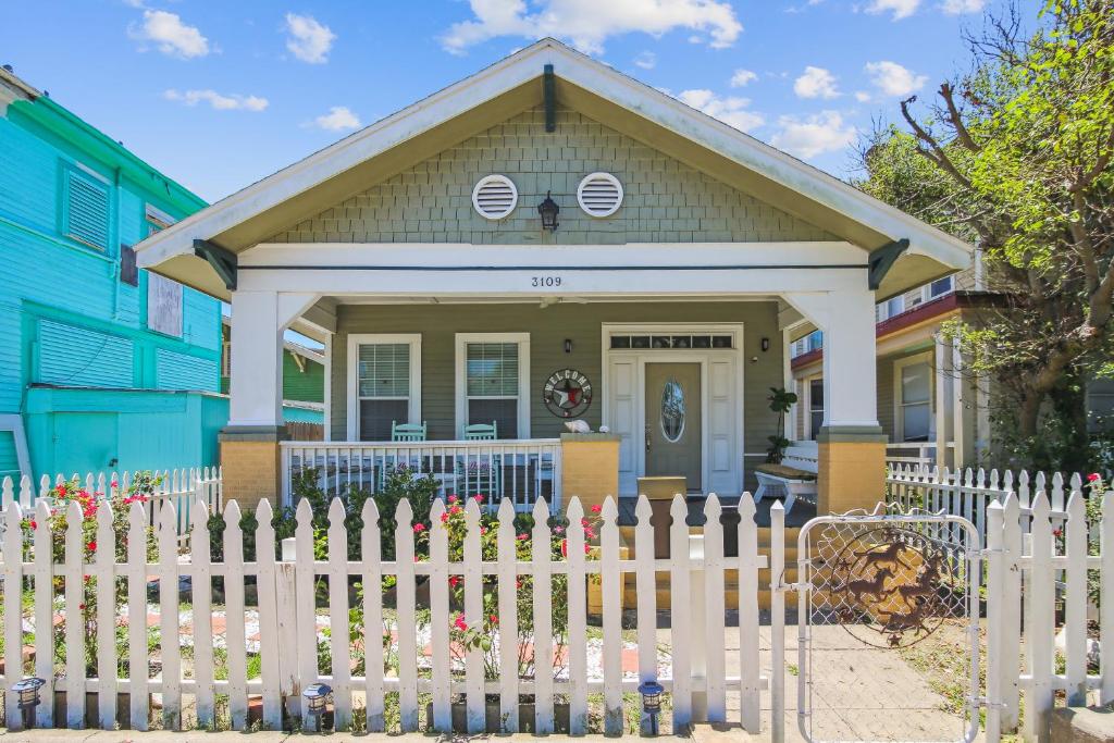 une clôture blanche devant une maison dans l'établissement A Beach Spot, à Galveston