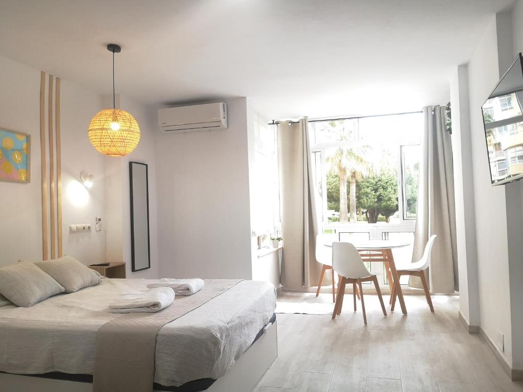 a white bedroom with a bed and a dining room at Cosy beach suite Agata in Benalmádena