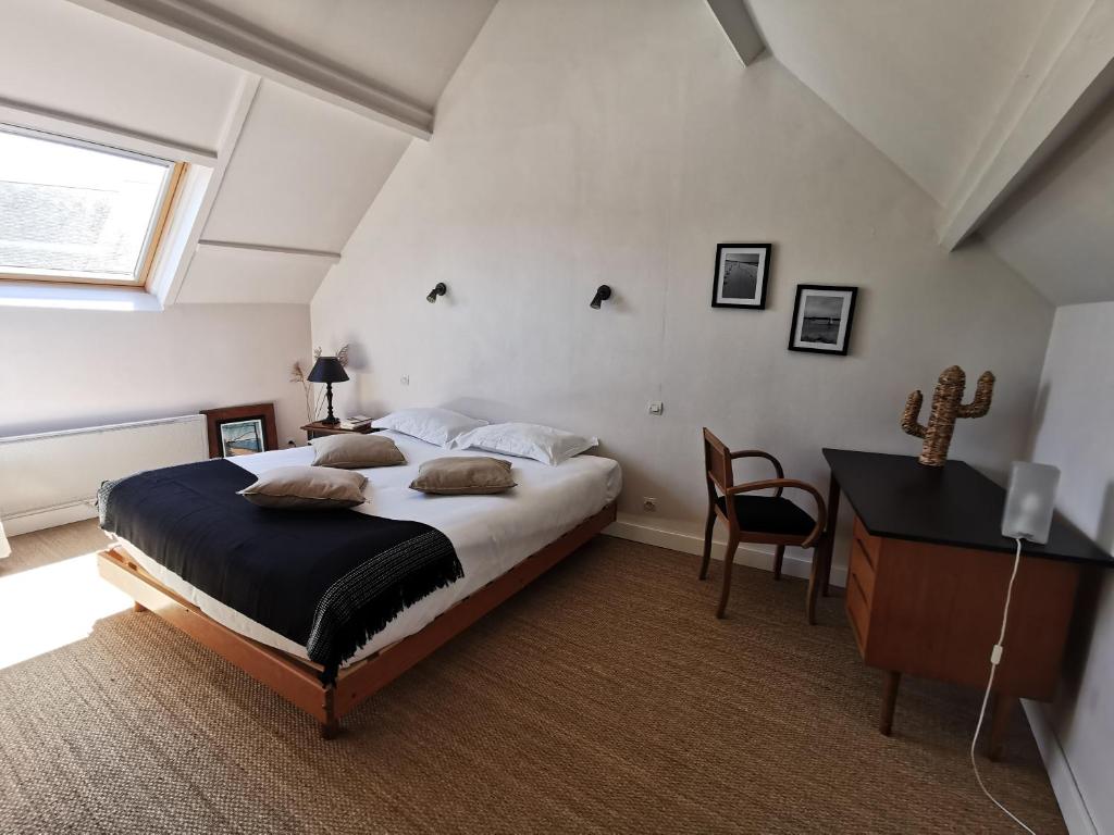 sypialnia z łóżkiem, biurkiem i oknem w obiekcie La P'tite Maison w mieście Bricqueville-sur-Mer