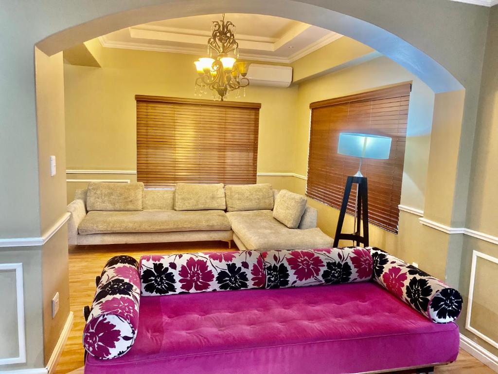 ein Wohnzimmer mit einem rosa Sofa in einem Zimmer in der Unterkunft Beautiful apartment in century city in Kapstadt