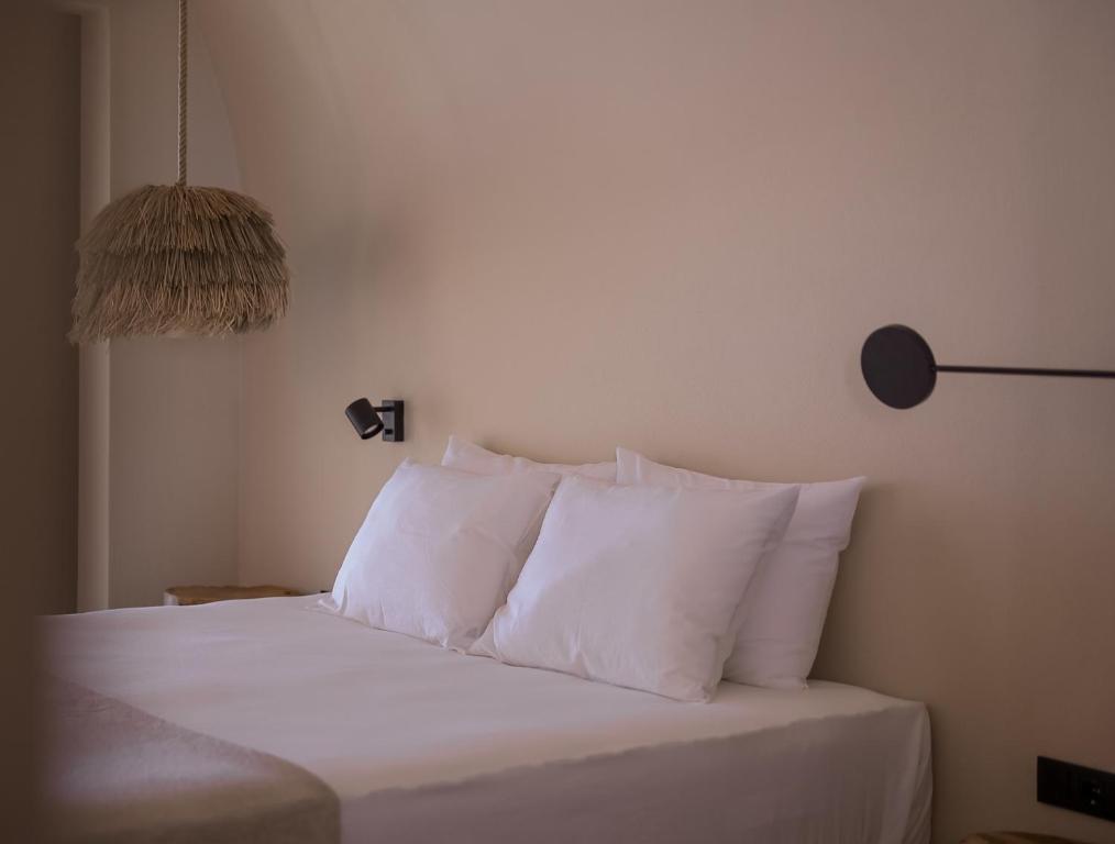 a bedroom with a bed with white sheets and pillows at GAIA Alaçatı BY THE SEA - Adult Only in Çeşme