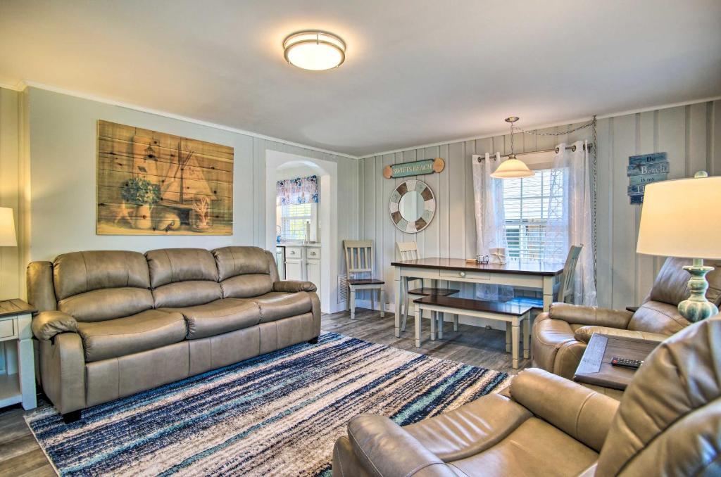 a living room with a couch and a table at Wareham Cottage with Deck, Walk to Swifts Beach in Wareham