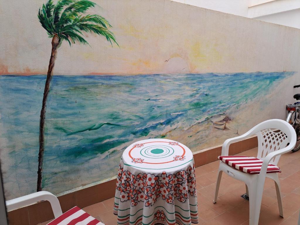 トレビエハにあるTorrevieja Playa Locosの絵の前のテーブルと椅子2脚