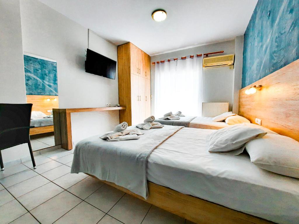 a hotel room with two beds and a television at Rooms Anastasia Paralia in Katerini