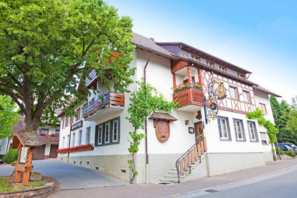 a white building with balconies on a street at Hotel Gasthof Engel in Appenweier