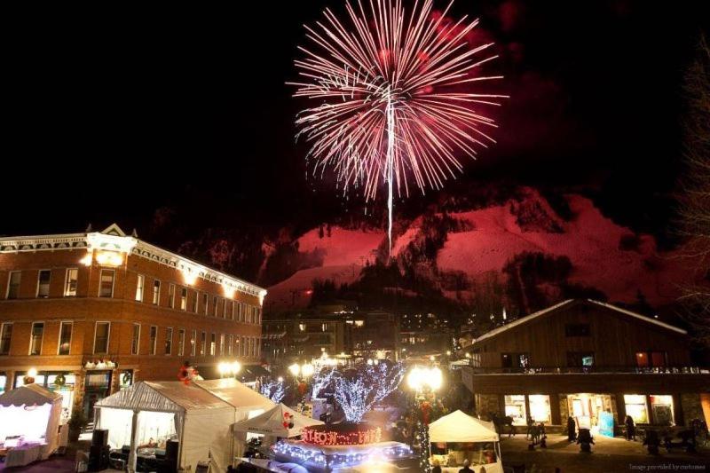 a firework display in a city with a crowd of people at Luxury 2 Bedroom Mountain Vacation Rental In The Heart Of Downtown Aspen One Block From Silver Queen Gondola in Aspen