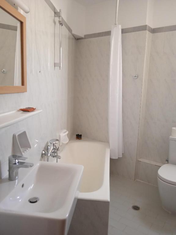 a bathroom with a sink and a tub and a toilet at Pal Beach in Palaiochora
