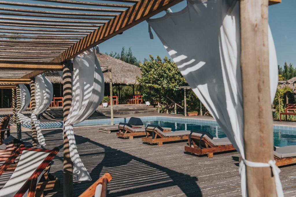 um resort com piscina e espreguiçadeiras em Ventana Hotel em Praia do Preá