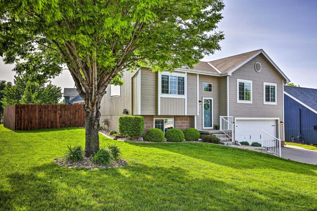 a house with a tree in a yard at Bright Omaha Family Home with Grill and Deck! in Omaha