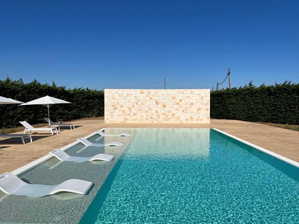 einen Pool mit Stühlen und Sonnenschirmen in der Unterkunft Dependance di Villa Melissa in Parabita