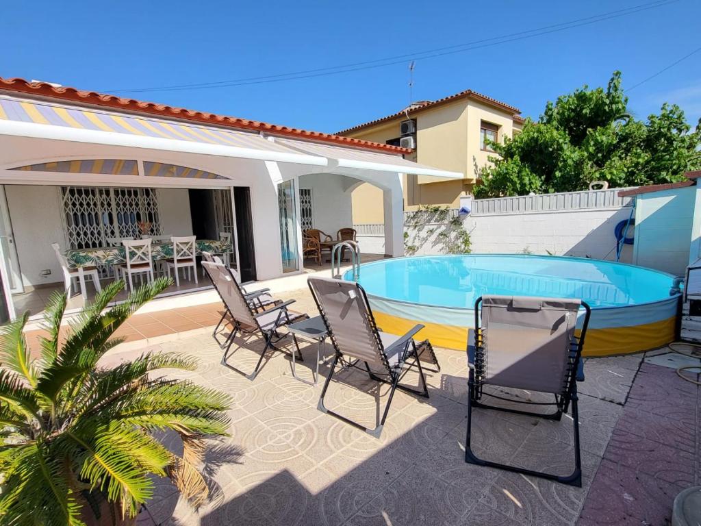 patio con sedie e piscina di Torredembarra cosy, well equipped house, 5 min. from the beach a Torredembarra