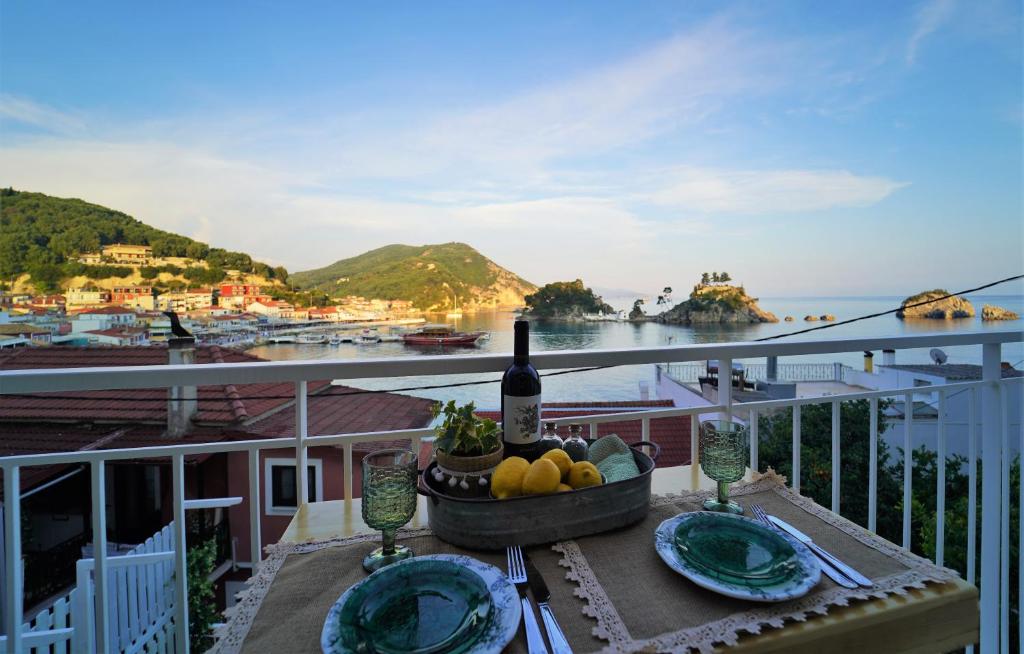 a table with a bottle of wine and fruit on a balcony at TheHouse1905 in Parga