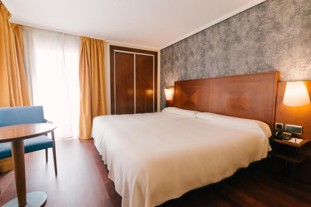 Habitación de hotel con cama, mesa y silla en Torreluz Centro, en Almería