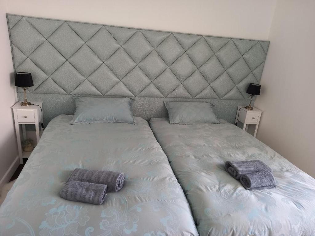 a large bed with two pillows on top of it at Parisian Sparkle Retreat in Neuilly-sur-Seine