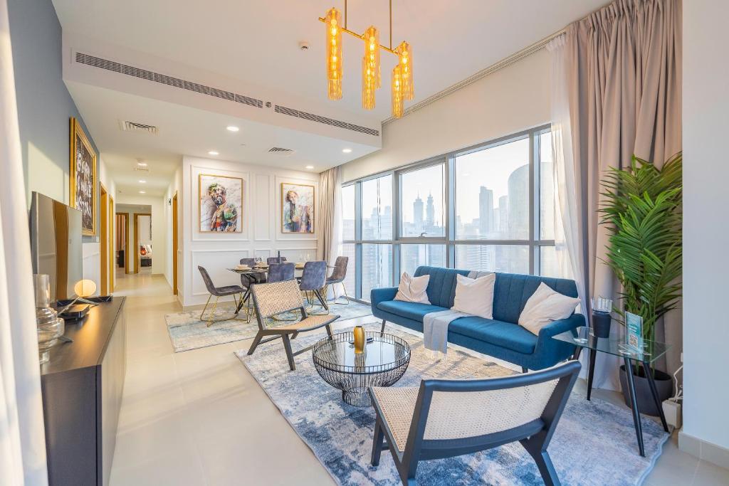sala de estar con sofá azul y sillas en Spacious Art Deco Apt with Burj & Canal Views, en Dubái