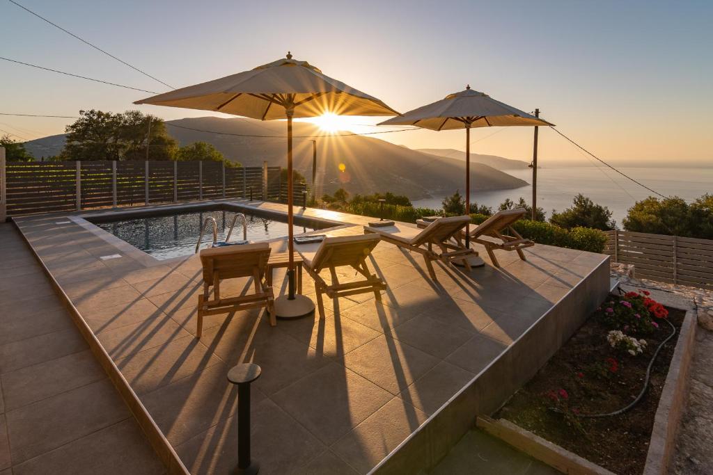 eine Terrasse mit 2 Tischen und 2 Sonnenschirmen in der Unterkunft Villa Athina in Anomeriá