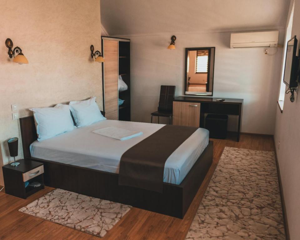 a bedroom with a bed and a desk and a mirror at Delta Est Hotel & Restaurant in Sulina