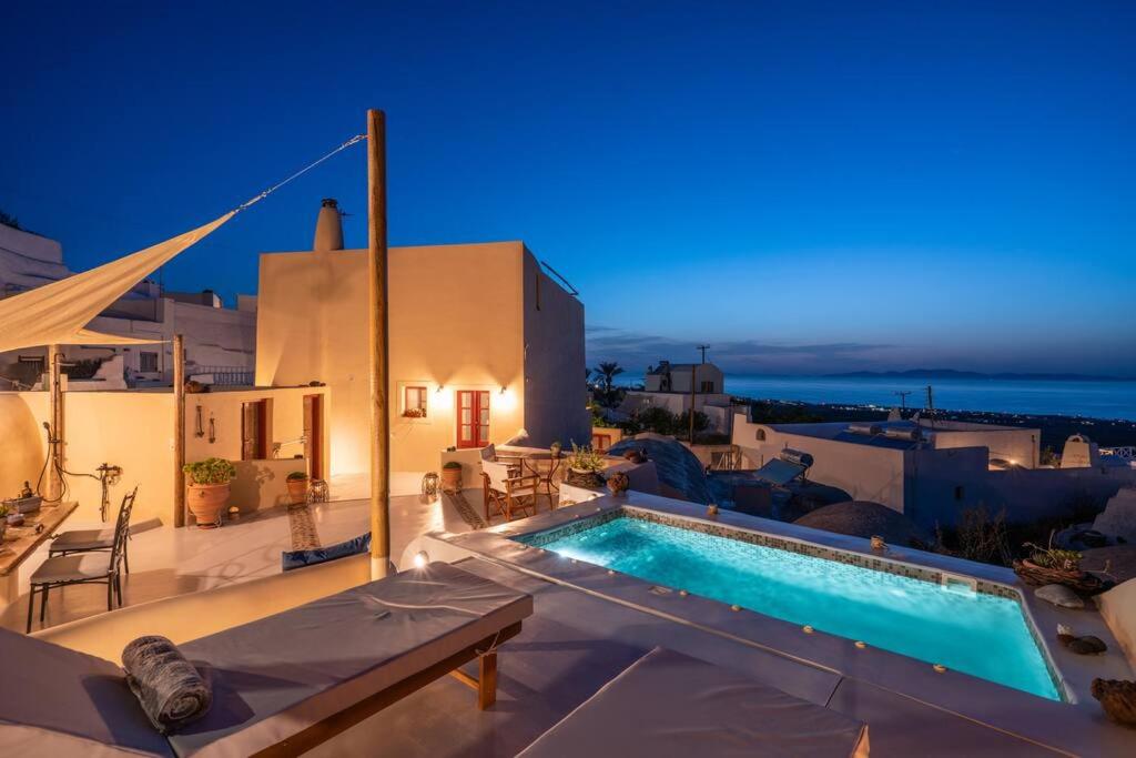 a pool on the roof of a house at night at Casa Terra Vedema Oia - Privacy - Plunge Pool & Panoramic Sunset Terrace in Oia