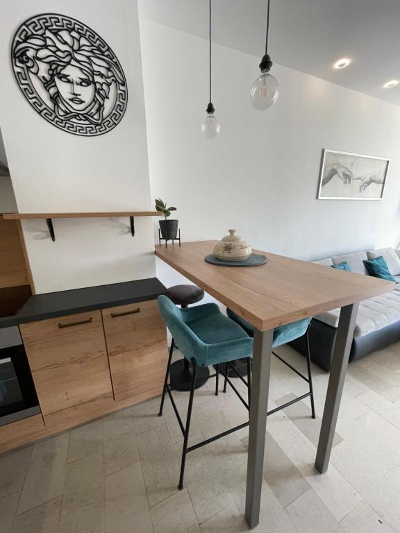une cuisine avec une table en bois et une chaise bleue dans l'établissement Oliver, à Ankaran
