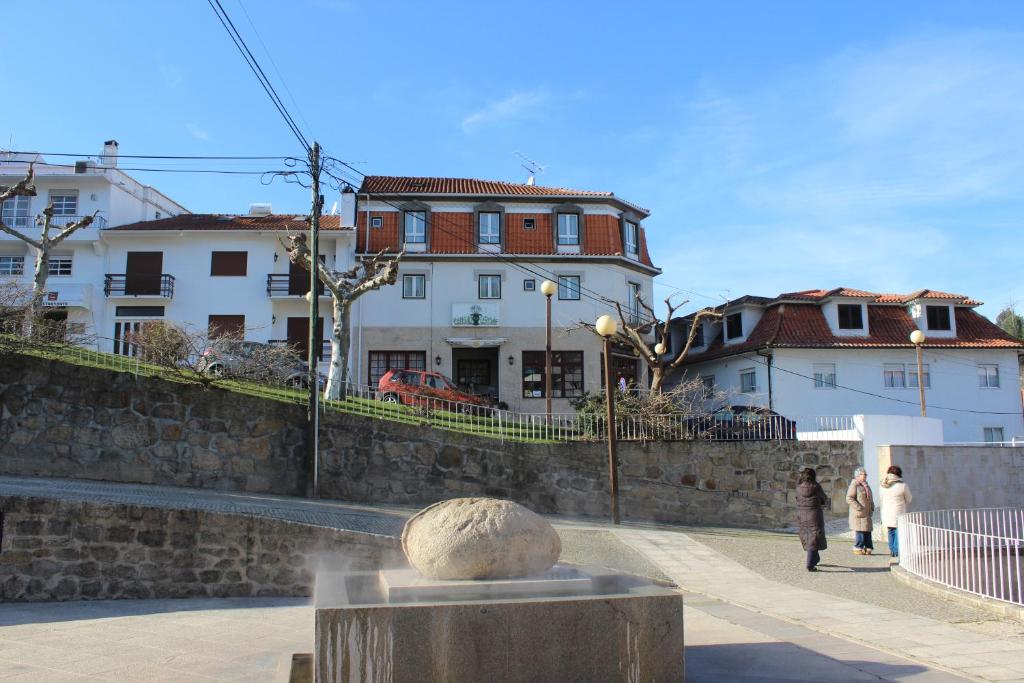 a group of people walking down a street next to buildings at Hot Water Guest House in Termas de Sao Pedro do Sul