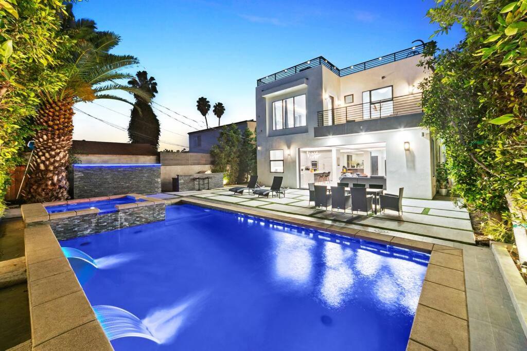 a large swimming pool in front of a house at Beverly Hills LUX Villa w. Pool, Rooftop & Parking in Los Angeles