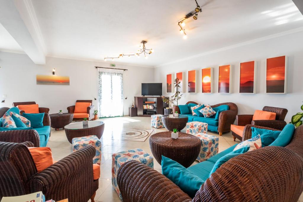 a living room with couches and chairs and a television at Dilina Studios in Arkasa