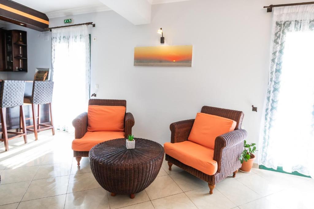 a living room with two chairs and a table at Dilina Studios in Arkasa