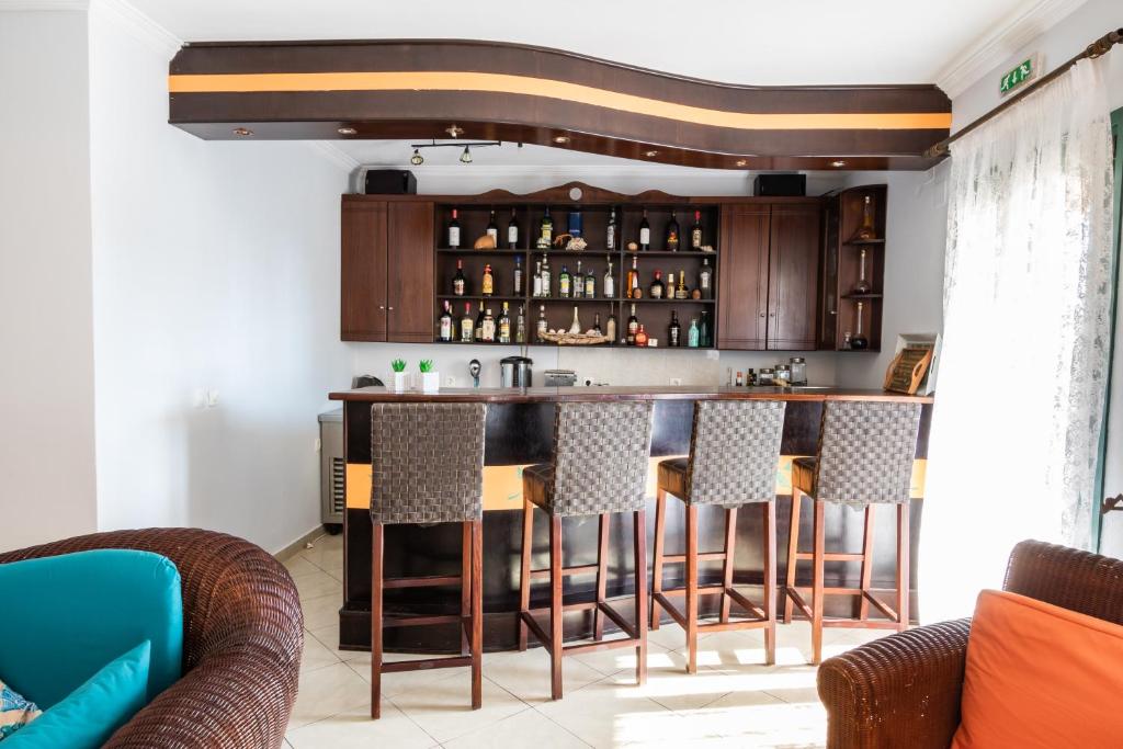 a kitchen with a bar with bar stools at Dilina Studios in Arkasa