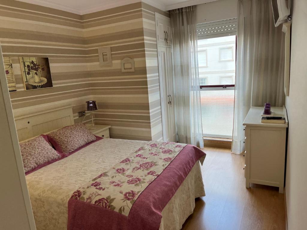 - une chambre avec un lit et une fenêtre dans l'établissement Apartamento ALBAMAR SANXENXO, à Sanxenxo
