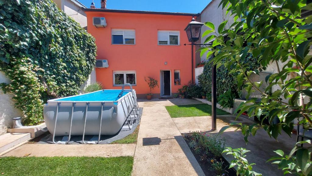 モスタルにあるVilla Secret Gardensの庭にスイミングプールがある家