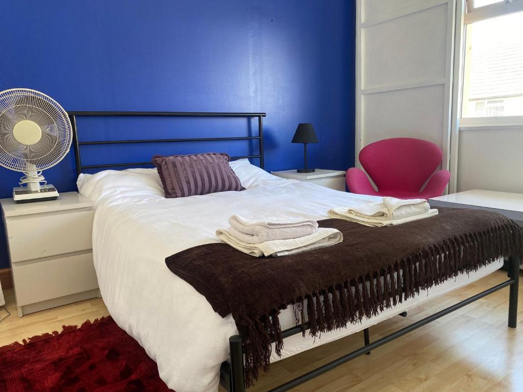 Beautiful Brighton House - Free Parking في بورتسليد: غرفة نوم بسرير مع مروحة وكرسي