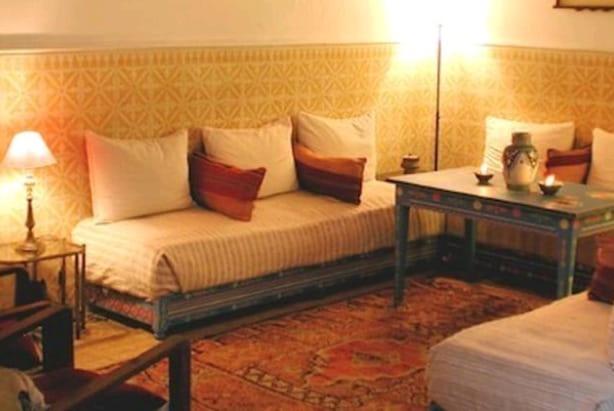 a room with a bed and a table with pillows at Riad Dar Latifa in Essaouira