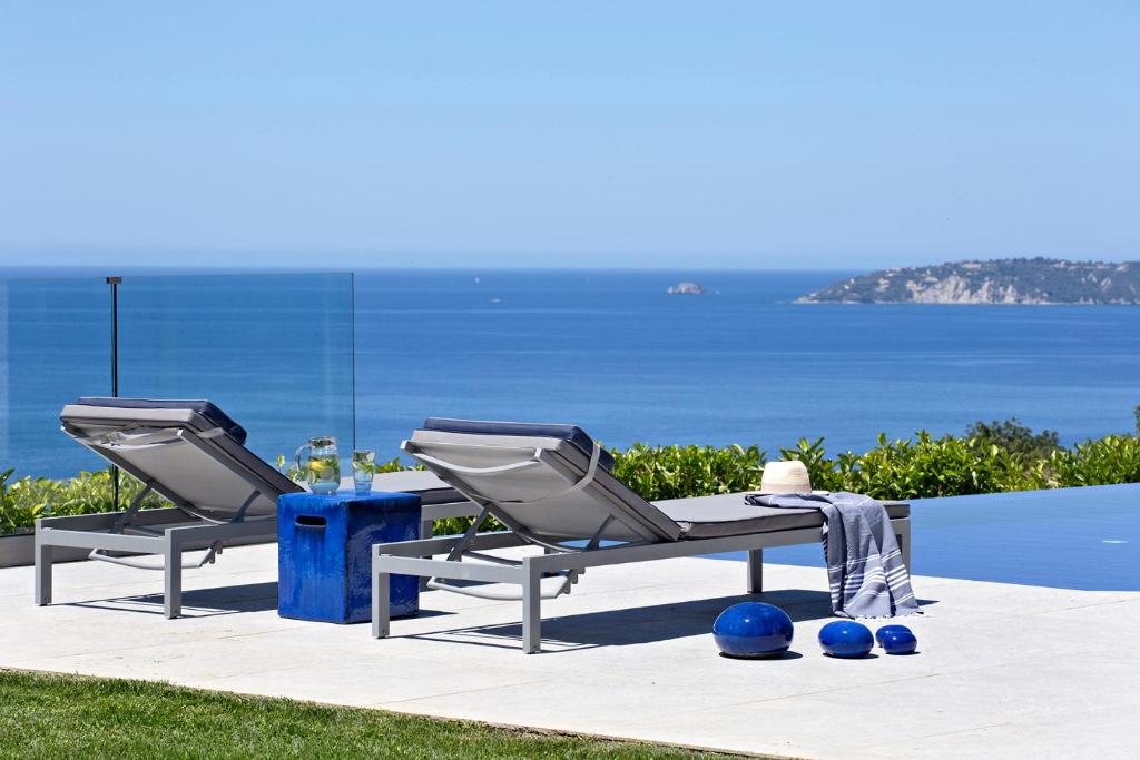 Plateies的住宿－Casa Assisi Luxury New Villa with Private Pool，两张躺椅和一张桌子,享有海景