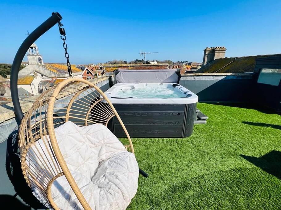 a swing on a yard with a hot tub at 2 Bed Harbourside Penthouse with Hot Tub & Roof Terrace in Weymouth