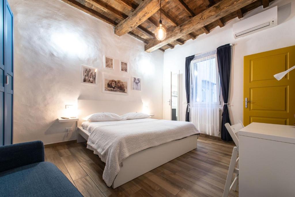 ein weißes Schlafzimmer mit einem Bett und einem Fenster in der Unterkunft Florence David's Guesthouse in Florenz