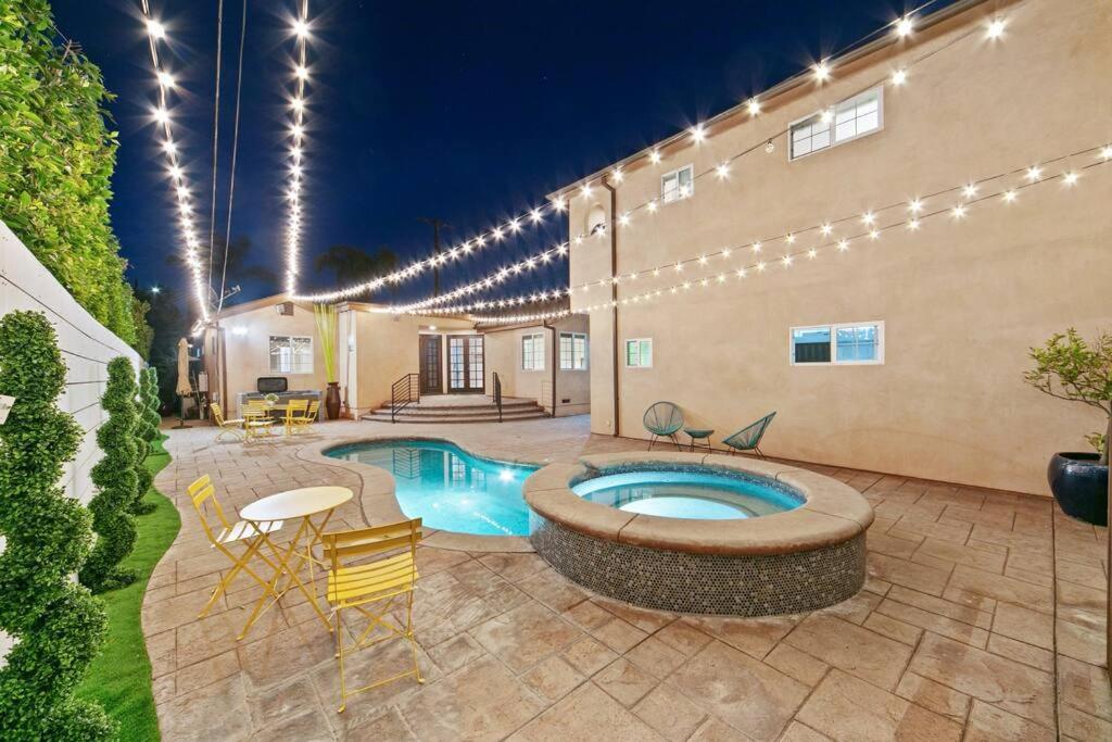 a patio with a pool and a building with lights at Beverly Grove Spanish Oasis with Pool and detached Guest House in Los Angeles