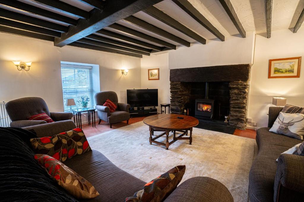 a living room with a couch and a fireplace at Ty Canol Maentwrog, Snowdonia Nr Zip World in Maentwrog