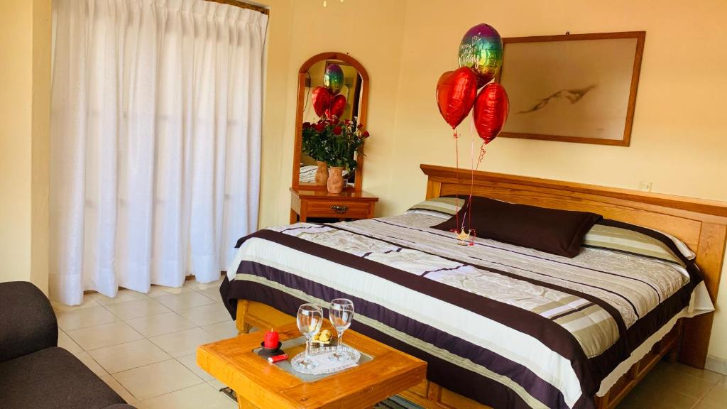 a bedroom with balloons and a bed with a table at Posada El Campanario in Valle de Bravo