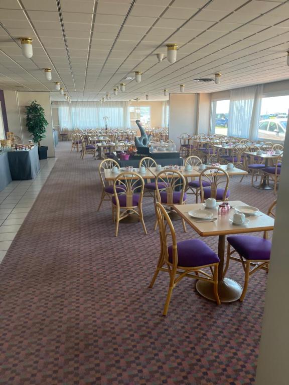 a dining room with tables and chairs and tablesearcher at Hotel de l&#39;Europe in Dieppe